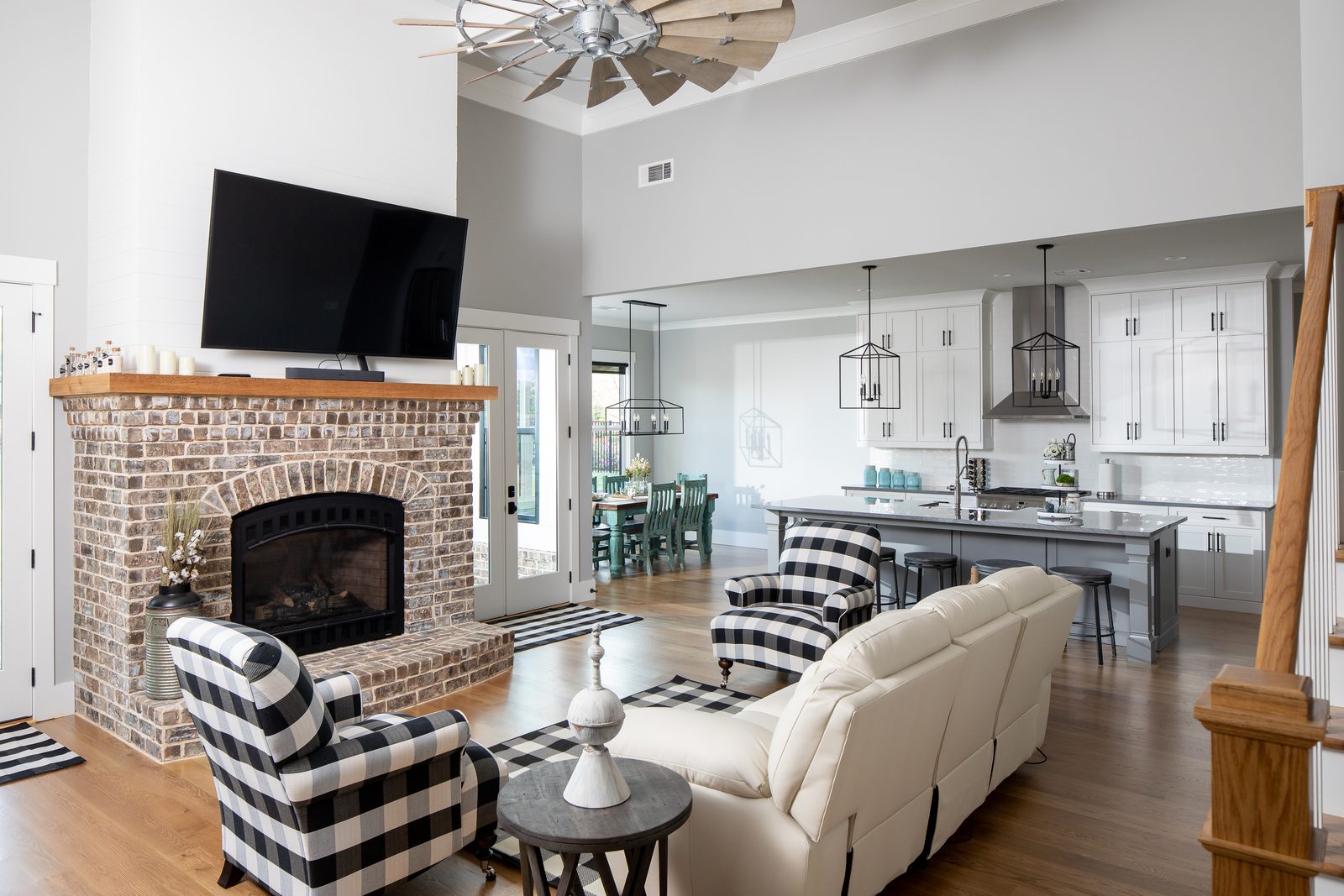 Great room with buffalo-check chairs beside the brick fireplace — Spring 2020 Custom Home, custom home built by Ironwood Construction Group