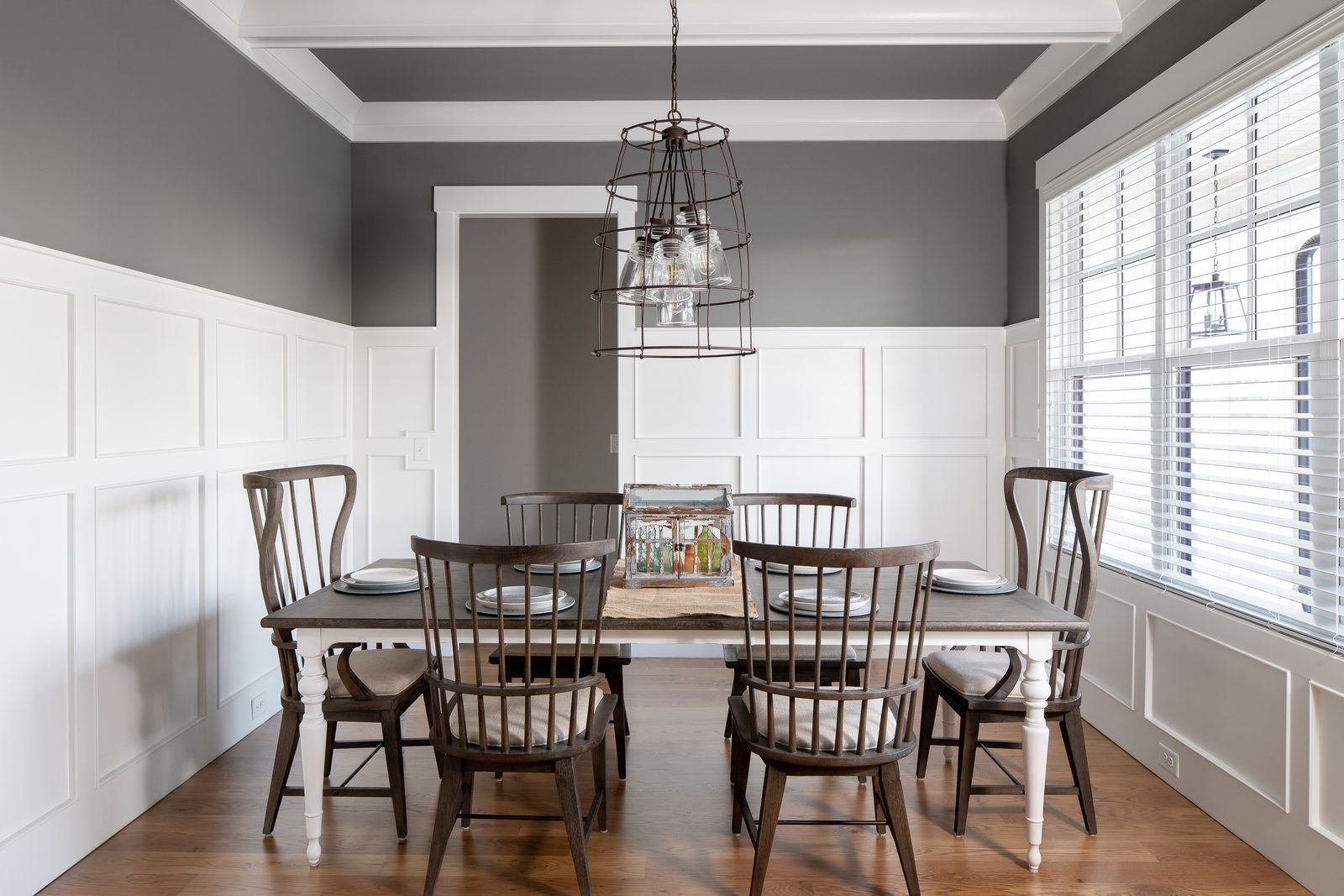 Dining room with board-and-batten wainscoting and lantern chandelier — Spring 2020 Custom Home, custom home built by Ironwood Construction Group